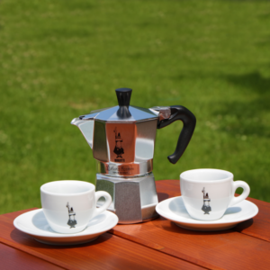 BIALETTI MOKA OMINO kávéfőző + 2 db csésze Olasz minőség és dizájn. A Moka Express a világ első számú kávéfőzője, több mint 330 millió darabot gyártottak le belőle. Klasszikus háztartási kávéfőző, mely magán hordozza kivételes védjegyeét: a bajszos kis emberkét (l’omino con i baffi).  A Bialetti az eredeti "kotyogós" kávéfőző, egyenesen a feltalálótól, a Bialetti cégtől. Működése és megjelenése közel 80 éve meghatározó a kotyogós kávéfőzők kedvelői körében. Gáz, elektromos és kerámia főzőlapon használható. Alumíniumból készül, mosogatógépben nem mosható. 
